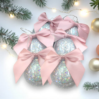Decorative Christmas ornaments with pink bows on a festive background