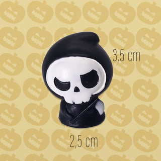 Skull-shaped object with black hood on a patterned background
