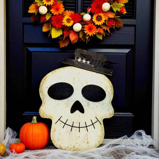 Halloween decoration with skull, pumpkins, and wreath on a door