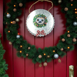 Decorative wreath with a sloth design on a red door with Christmas decorations.
