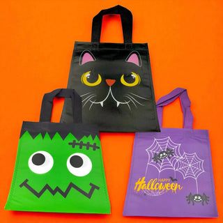 Three Halloween-themed tote bags on an orange background
