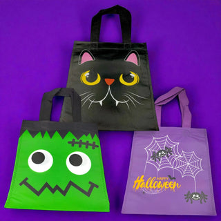 Three Halloween-themed tote bags on a purple background