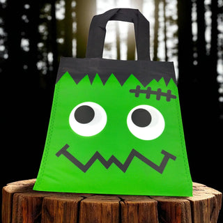 Green monster-themed bag with black accents on a wooden surface against a dark background