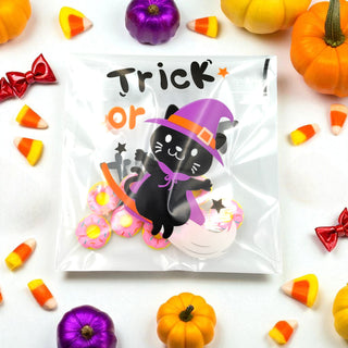 Halloween-themed treat bag with a black cat in a purple witch hat surrounded by candy and pumpkins on a white background.