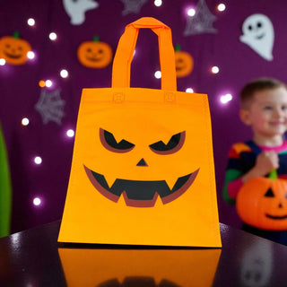 Halloween-themed orange bag with a jack-o'-lantern face design on a purple background with Halloween decorations.