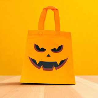 Orange tote bag with a jack-o'-lantern face design on a yellow background