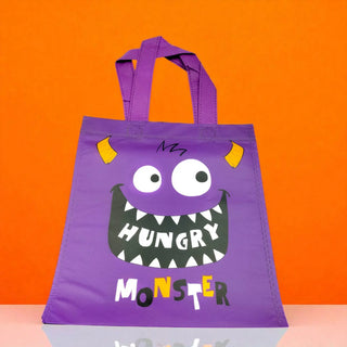 Purple tote bag with a monster design on an orange background