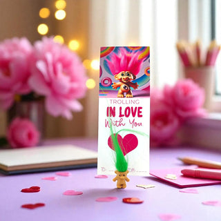 Valentine's Day card with cartoon character and decorative pen on a table with flowers and stationery.