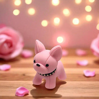 Pink dog-shaped figurine on a wooden surface with blurred lights and pink flowers in the background