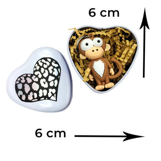Heart-shaped box with a monkey figurine and leopard print heart on a white background