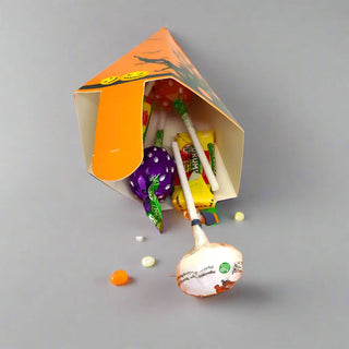 Halloween-themed candy bag with lollipops and small candies on a gray background