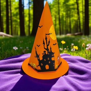 Halloween-themed paper cone with a haunted house design on a purple blanket in a forest setting.