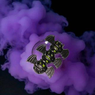 Three-dimensional bat-shaped object with glowing eyes against a purple smoke background