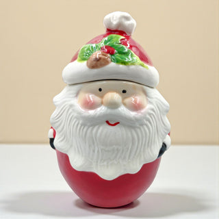 Vintage-inspired Santa treat jar displayed on a neutral kitchen shelf with greenery and fairy lights, warm holiday vibes.