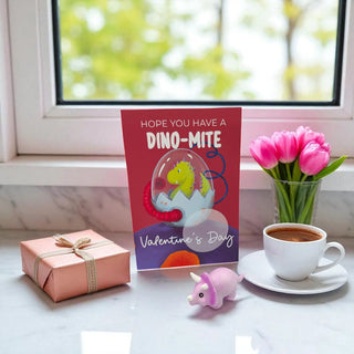 Valentine's Day card with dinosaur design, gift, cup of coffee, and flowers on a windowsill.