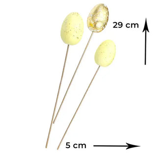 yellow and gold easter eggs on a stick with a white background