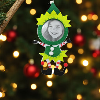 Elf-shaped photo frame ornament with a blurred Christmas tree background