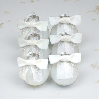 Decorative Christmas ornaments with white bows on a light gray background