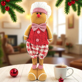 Gingerbread man toy in a kitchen setting with a cup of coffee and Christmas decorations.