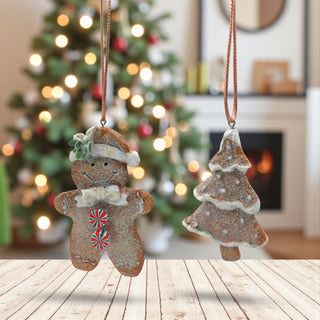 Two Christmas-themed ornaments, a gingerbread man and a tree, hanging against a festive background with a decorated tree and fireplace.