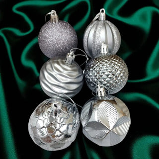 Set of silver Christmas ornaments with a green and black background