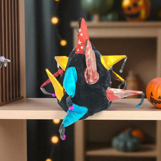 Colorful dragon toy on a shelf with Halloween decorations in the background