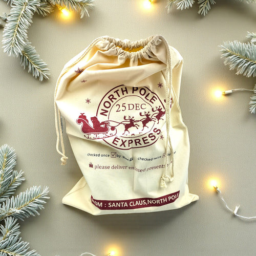 Christmas-themed drawstring bag with Santa Claus and reindeer design on a light background.