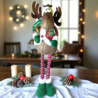 Decorative reindeer figure with Christmas decorations on a table.