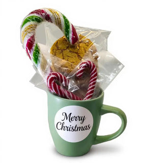 Green mug with 'Merry Christmas' label, candy canes, and cookies on a white background