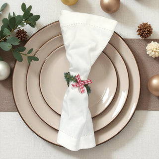 Napkin with Christmas design on a set of plates with decorative elements.