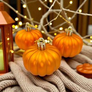 Three small pumpkins on a textured surface with warm lighting in the background