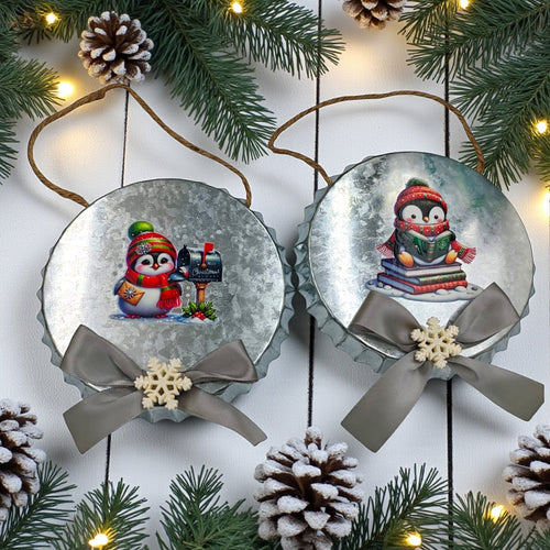 Two Christmas-themed snow globe ornaments with penguins on a decorative background with pine branches and lights.
