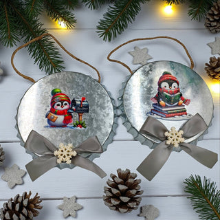 Two Christmas ornaments with penguins and ribbons on a white background
