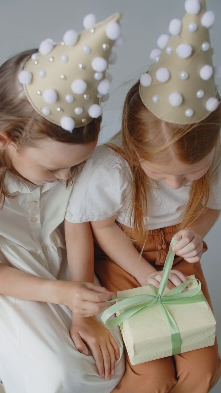 two young girls opening a present