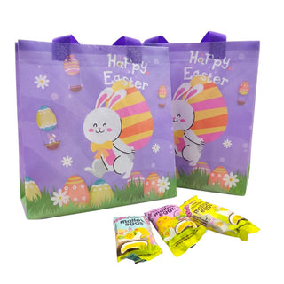 Two Easter-themed gift bags with a bunny and egg design, accompanied by small packages of M&M's on a white background.