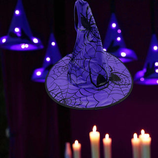 Halloween-themed hat with spider webs and glowing candles on a dark background