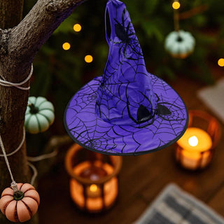 Purple Halloween decoration with spider design hanging on a tree branch.