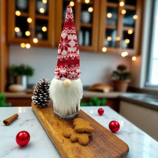 Decorative Christmas gnome on a wooden board with pine cones and cookies in a kitchen setting.
