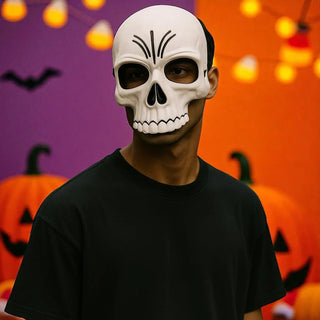 Person wearing a skull mask with Halloween decorations in the background