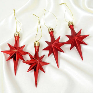 Red star-shaped ornaments with gold bases on a white background