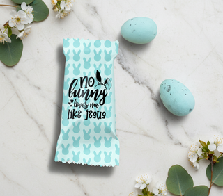 Blue Easter Egg with bunny pattern and text on a marble surface with Easter eggs and flowers.