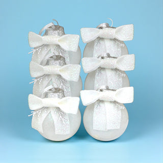 Decorative Christmas ornaments with white bows on a light blue background