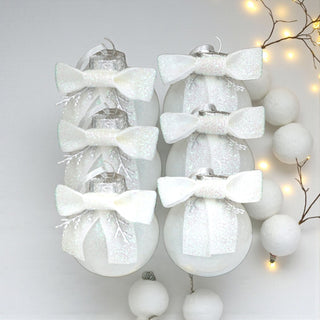 Decorative Christmas ornaments with white bows on a light gray background