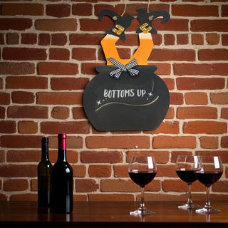 Decorative sign with 'Bottoms Up' on a brick wall with glasses.