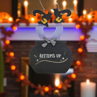 Decorative sign with 'BOTTOMS UP' text in a festive setting with candles and lights.