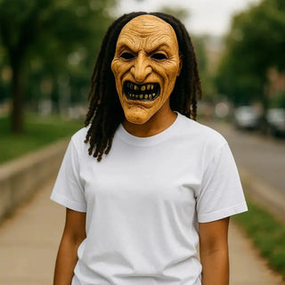 Person wearing a witch mask with a blurry suburban background